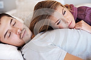 She feels secure in his love. Attractive young couple lying together at home.