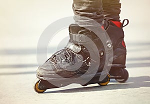 Feet of aggressive inline rollerblader on outdoor skatepark