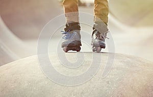 Feet of aggressive inline rollerblader on outdoor skatepark