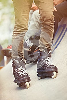 Feet of aggressive inline rollerblader on outdoor skatepark