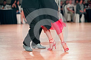 Feet of Argentinian tango dancers on a dancing parquet