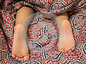 Feet baby boy sleeping on the carpet.