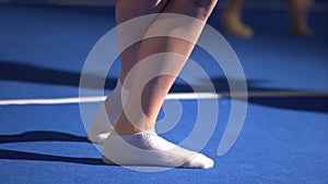 Feet of ballet-dancer are in a hall