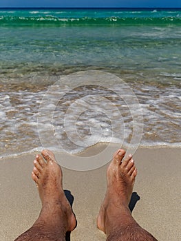 Feet on the beach enjoying the relax and the amazing view of paradisiac sea