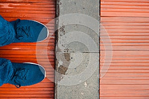 Feet in blue shoes standing on wood vinyl floor