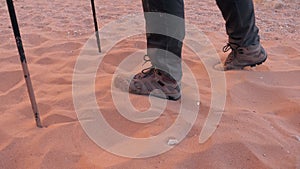 Feet in boots tired exhausted traveler trudge through the dry sandy desert