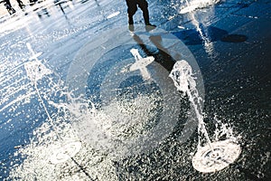 Feet of boy running playing with a water fountain in a park in summer