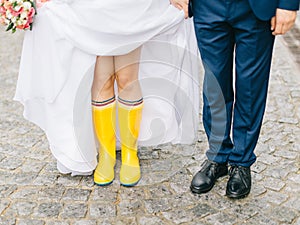 Feet of the bride and groom walk in rainy weather