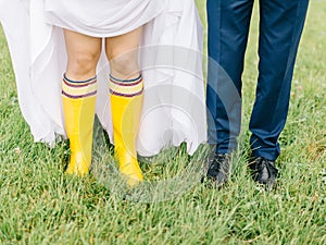 Feet of the bride and groom walk in rainy weather