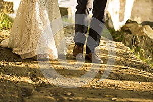 feet of bride and groom walking, wedding shoes (soft focus). Cross processed image for vintage look