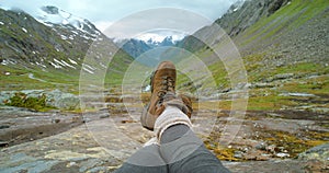 Feet of a carefree woman enjoying a landscape view of a beautiful valley while hiking and exploring on a journey of