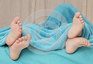 Feet of children lying on the bed