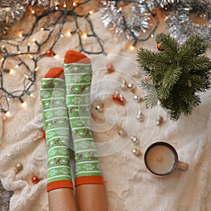 Feet in christmas socks near the Christmas tree