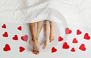 Feet close up of young loving couple enjoying on the bed