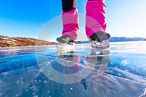 Feet close-ups of skates on legs A brightly colored dressed woman on the blue ice of Lake Baikal