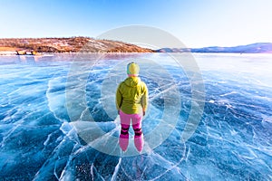 Feet close-ups of skates on legs A brightly colored dressed woman on the blue ice of Lake Baikal