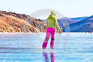 Feet close-ups of skates on legs A brightly colored dressed woman on the blue ice of Lake Baikal