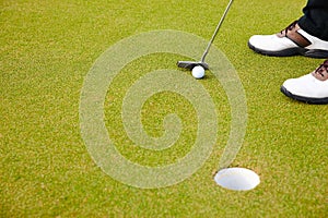 Feet, club and golf ball for hole on field, training and practice for competition or tournament. Closeup, shoes and