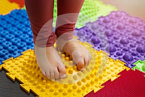Feet correction and massage - child walking on orthopedic floor mat