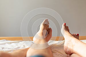 Feet of couple on the bed. Man and woman resting love on bed. lovers concept.Closeup.Copy space