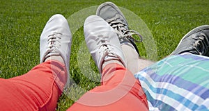 Feet of a couple lying on grass