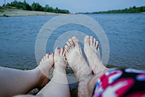Feet of the couple, by the river, enjoy a beach holiday, buzz and relaxation