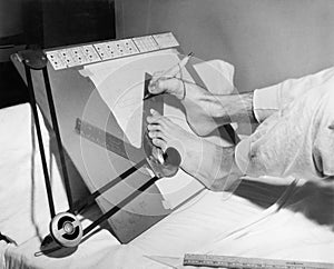 Feet of a disabled man using a drafting board photo