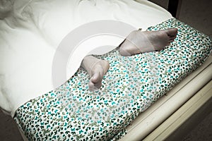 Feet of a dying patient lying on a mobile bed in hospital