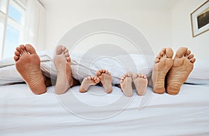 Feet, family and sleep in bedroom in home, relax in peace and rest in blanket in the morning together. Barefoot, bed and