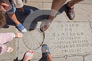 feet of a family of travelers with shell mark in Obradoiro Square