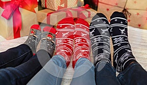 Feet of family in warm socks with winter holiday print