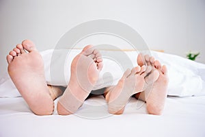 The feet or foot of couples sleeping on the bed