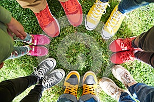 feet on green grass, standing in a circle. Top view.