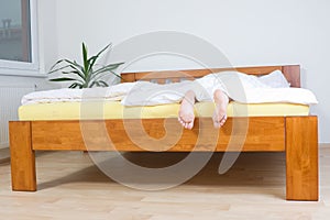 Feet hanging over end of bed