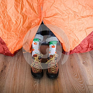 Feet in happy socks. Man is relaxing near tent and warming up his feet in happy socks.