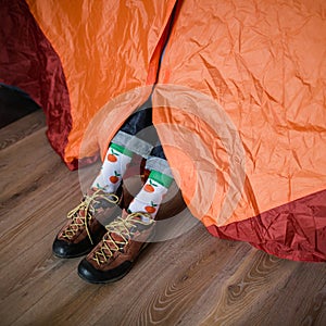 Feet in happy socks. Man is relaxing near tent and warming up his feet in happy socks.