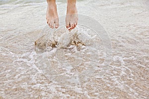 Feet of jumping boy at the beach