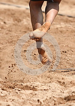 Feet and legs of a boy beach volleyball player