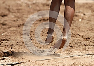 Feet and legs of a boy beach volleyball player