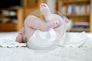 Feet and legs of newborn baby with diaper