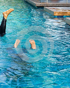 Feet looking out upside down from swimming pool. Summe fun vacation