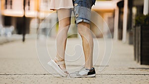 Feet of male and female close to each other, girl raising on tiptoes, dating