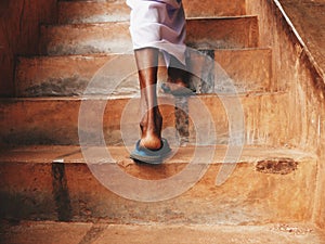 Feet of a man climbing stairs in Sigirya Rock in Sri Lanka