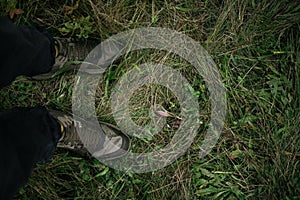Feet of a man in hiking boots standing on the grass