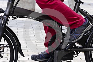 Feet of man pedaling on electric bicycle