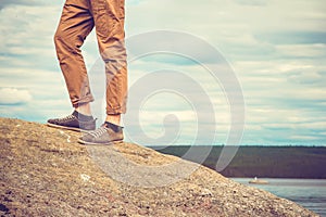 Feet man standing on rocky mountain outdoor