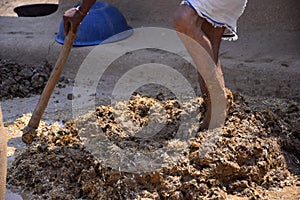 Feet of a man while trampling the soil to build a wall