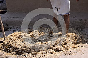 Feet of a man while trampling the soil to build a wall