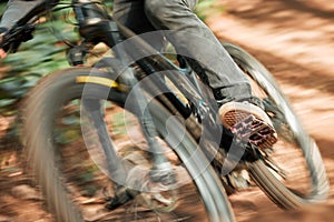 Feet, mountain bike pedal and speed in forest, closeup and training for health, wellness and outdoor adventure. Person