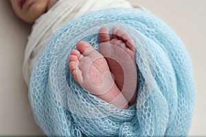 Feet of a new born in a blue blanket Close up of toes, heels and feet of newborn